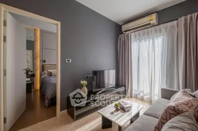 Modern living room with sleek furniture and natural light, adjacent to a cozy bedroom.