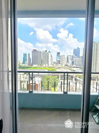 Stunning cityscape view from modern apartment balcony with clear blue sky.