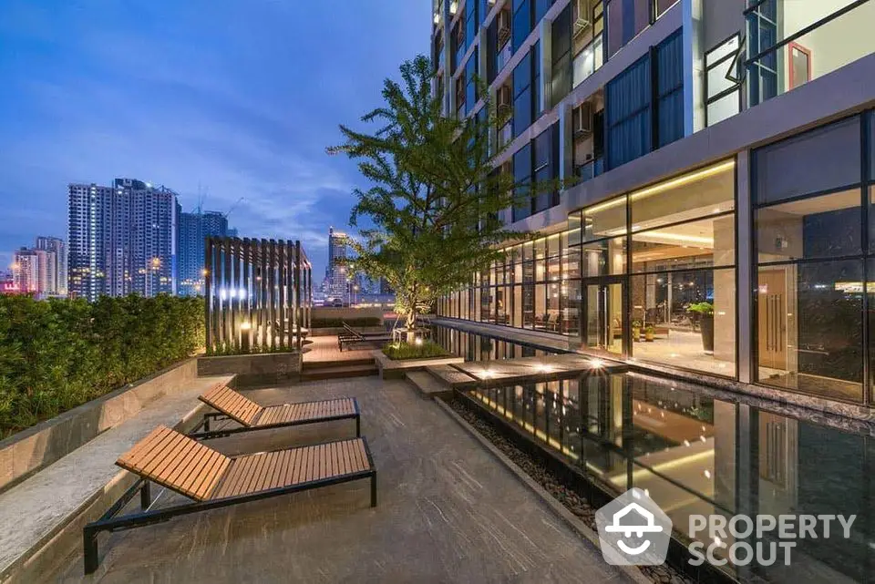 Luxurious modern apartment building with stunning pool and city view at dusk