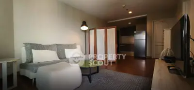 Modern living room with cozy sofa, stylish lamp, and open kitchen layout in a contemporary apartment.