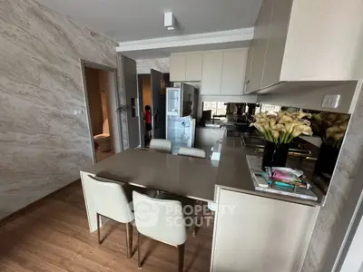 Modern kitchen with sleek dining area and stylish decor in a contemporary apartment.