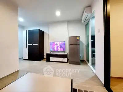 Modern living room with sleek furniture and TV, featuring air conditioning and open layout.