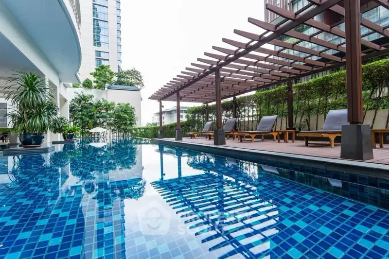 Luxurious outdoor pool area with modern design and lush greenery, perfect for relaxation and leisure.