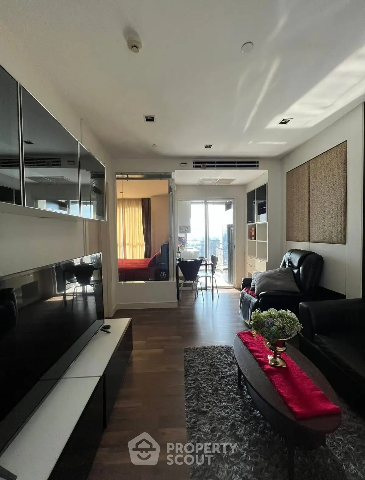 Stylish modern living room with sleek furniture and large TV, perfect for urban living.