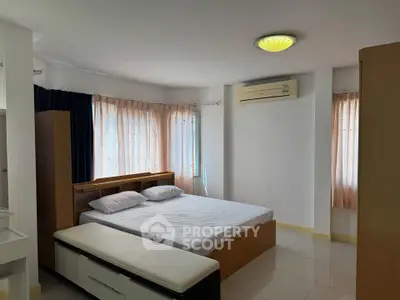 Spacious bedroom with natural light and modern furnishings in a cozy apartment.