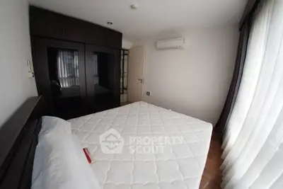Spacious bedroom with large windows and modern wardrobe in a stylish apartment.