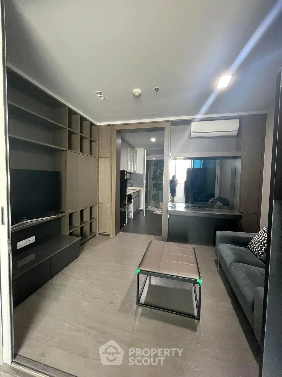 Modern living room with sleek furniture and open kitchen layout in a stylish apartment.