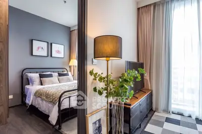 Modern bedroom with stylish decor and natural light, featuring a cozy bed and elegant furnishings.