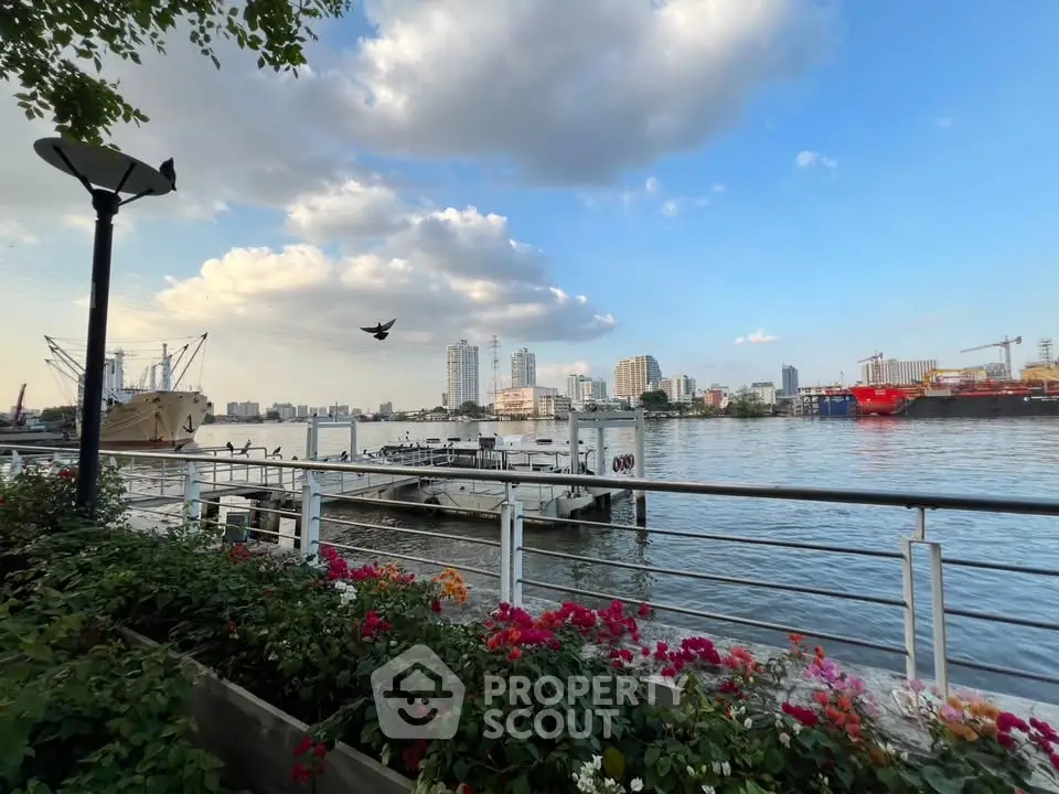 Stunning waterfront view with city skyline and vibrant flowers, perfect for serene living.