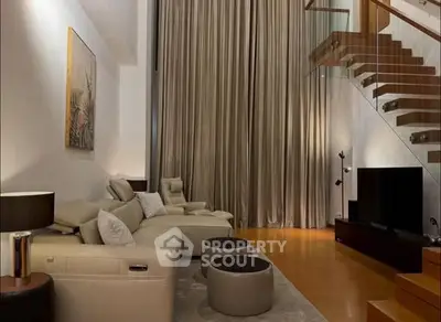 Luxurious living room with high ceilings and modern staircase