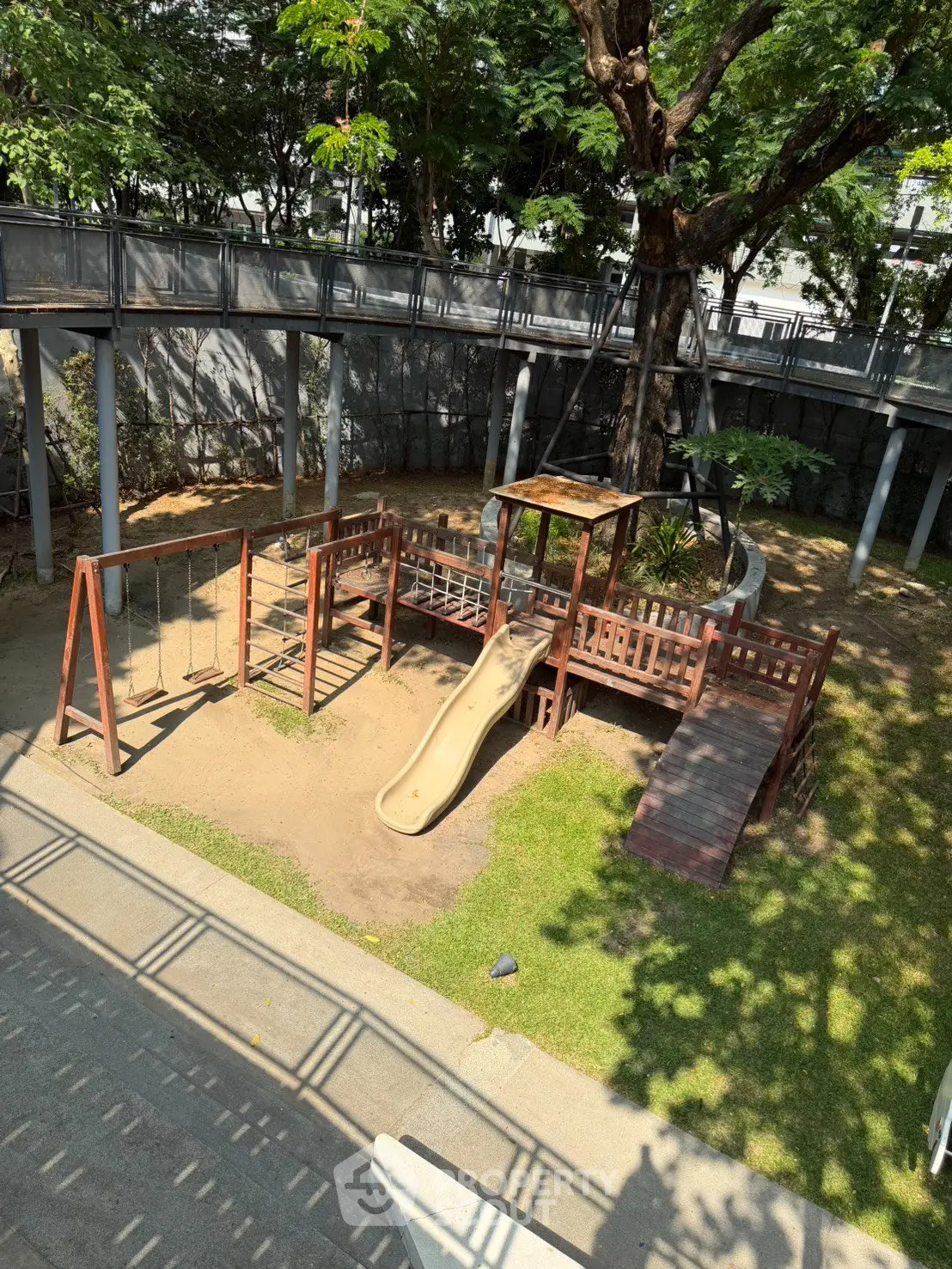 Charming outdoor playground area with slide and swings in a lush garden setting, perfect for family-friendly living.