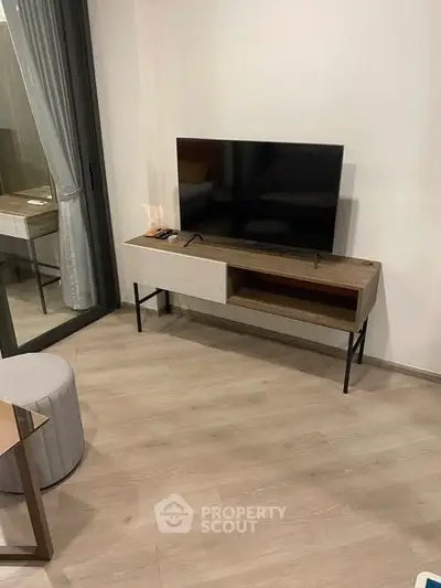 Modern living room with sleek TV stand and large window, perfect for urban living.