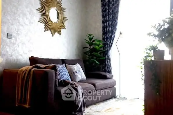 Cozy living room with stylish sofa, decorative mirror, and lush greenery.