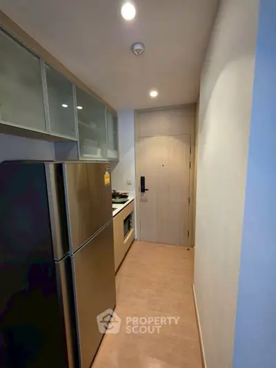 Modern compact kitchen with stainless steel appliances and sleek cabinetry