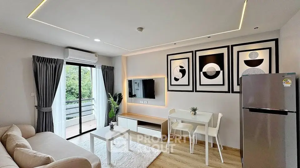 Modern living room with stylish decor, balcony access, and sleek kitchen appliances.
