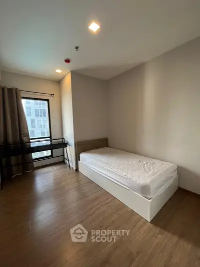 Spacious minimalist bedroom with single bed and large window view