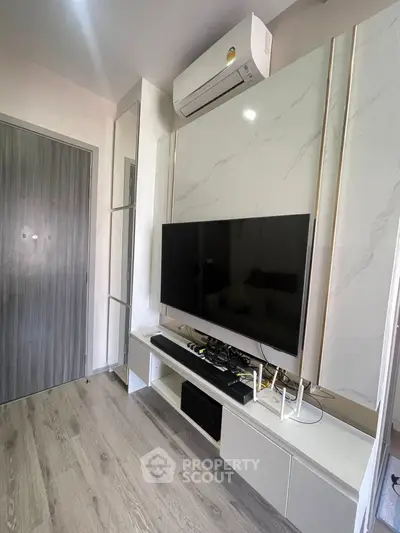 Modern living room with sleek TV setup and air conditioning unit