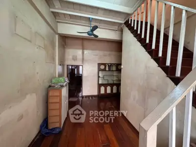 Charming rustic interior with wooden floors and staircase, perfect for renovation enthusiasts.