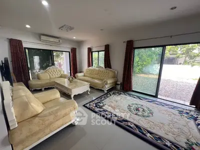 Elegant living room with plush sofas, large windows, and a beautiful garden view.