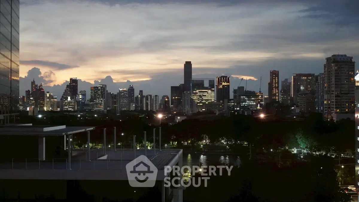 Stunning city skyline view at dusk with illuminated buildings and serene water reflection.
