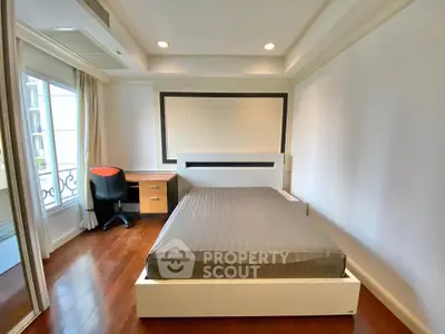 Spacious bedroom with modern design and large window offering natural light.
