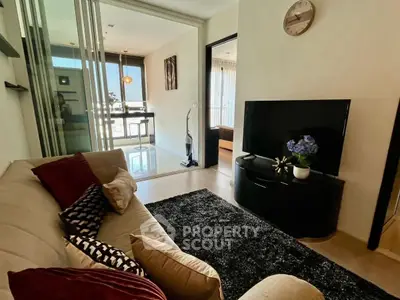 Cozy living room with modern decor and sliding glass doors leading to a bright dining area.