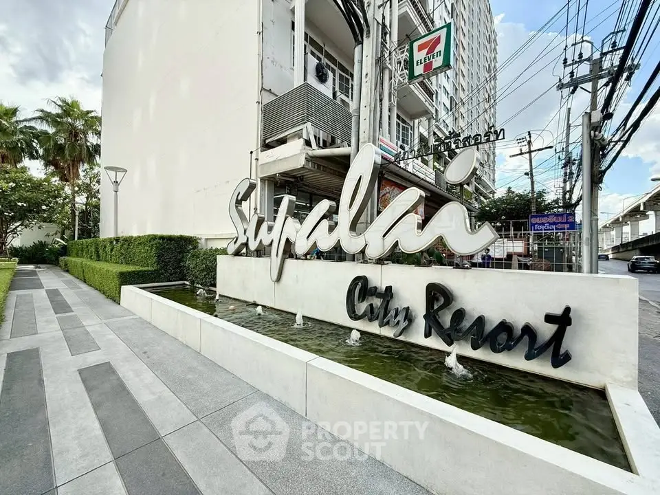 Modern city resort entrance with sleek signage and lush greenery