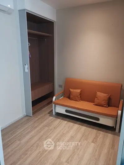 Cozy small living area with a convertible sofa and built-in closet, perfect for compact urban living.