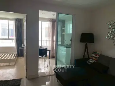 Modern apartment interior with open layout connecting living room, kitchen, and bedroom.