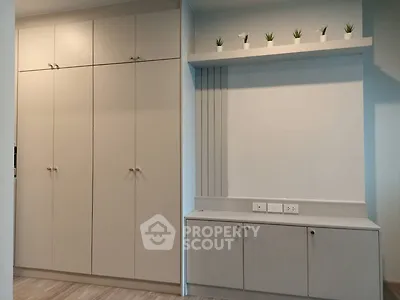 Modern storage space with sleek cabinets and decorative shelving in a stylish interior.