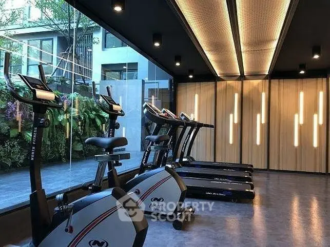 Modern gym with state-of-the-art equipment and stylish lighting in a luxury residential building.