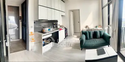 Modern living room with open kitchen and large windows offering natural light and city views.