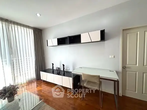 Modern study room with sleek furniture and natural light in a stylish apartment.
