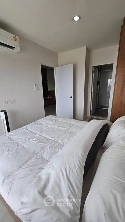 Cozy bedroom with modern decor and ensuite bathroom in a stylish apartment.