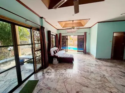 Spacious living room with pool view and marble flooring in luxury home