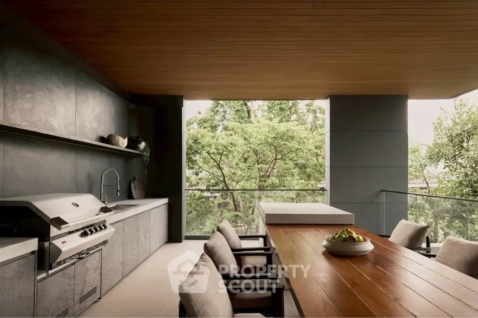 Luxurious outdoor kitchen with modern appliances and spacious dining area overlooking lush greenery.