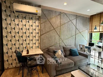Stylish modern living room with geometric accent wall and cozy seating area.