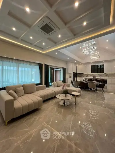 Luxurious open-plan living room with modern kitchen and elegant lighting.