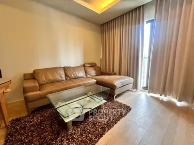 Modern living room with leather sofa and glass coffee table in a cozy apartment.