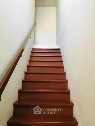 Elegant wooden staircase with sleek handrail in modern home interior