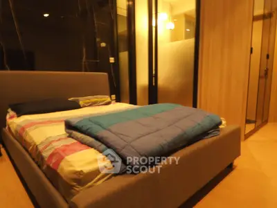 Cozy bedroom with modern design and warm lighting, featuring a comfortable bed and stylish decor.