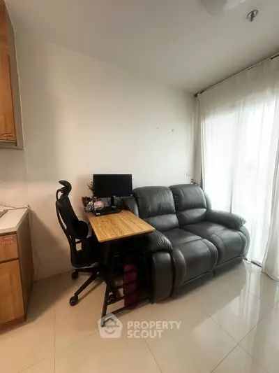 Cozy living room with modern desk and comfortable sofa, perfect for work and relaxation.
