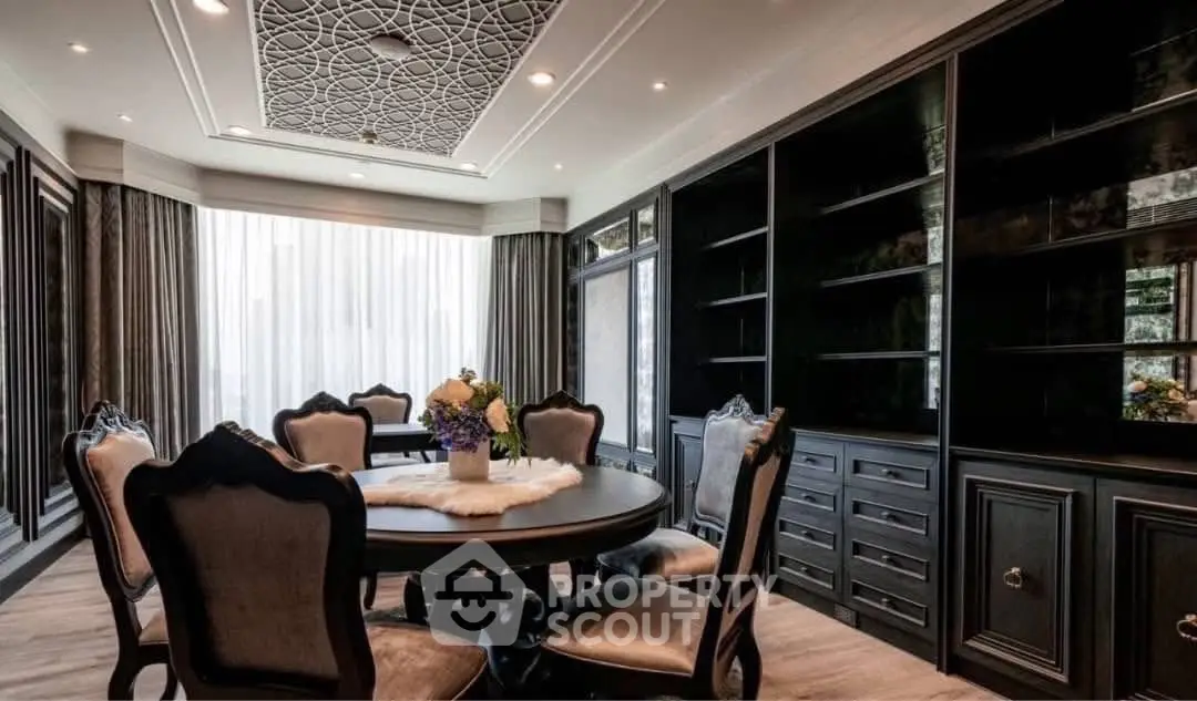 Luxurious dining room with elegant dark wood furniture and intricate ceiling design, perfect for sophisticated gatherings.