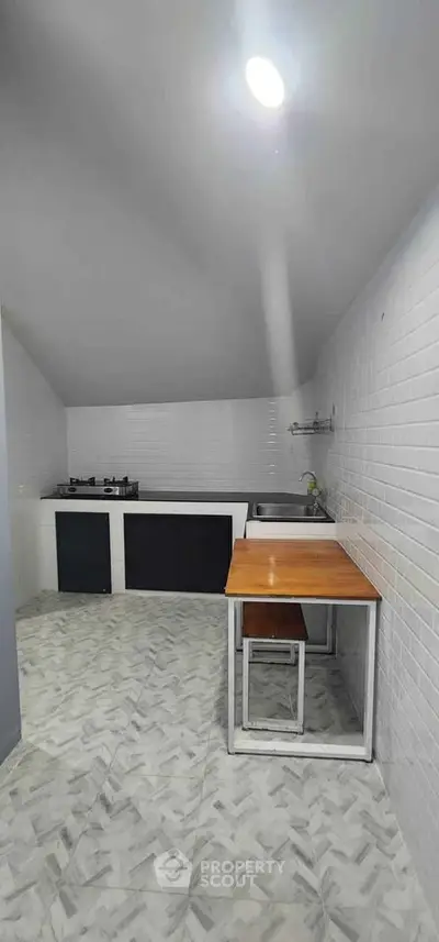 Modern minimalist kitchen with sleek design and gas stove, perfect for culinary enthusiasts.