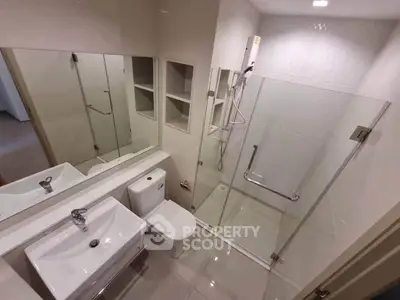 Modern bathroom with glass shower and sleek fixtures in a contemporary apartment.