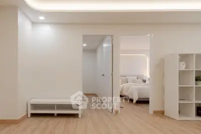 Modern minimalist bedroom with wooden flooring and soft lighting