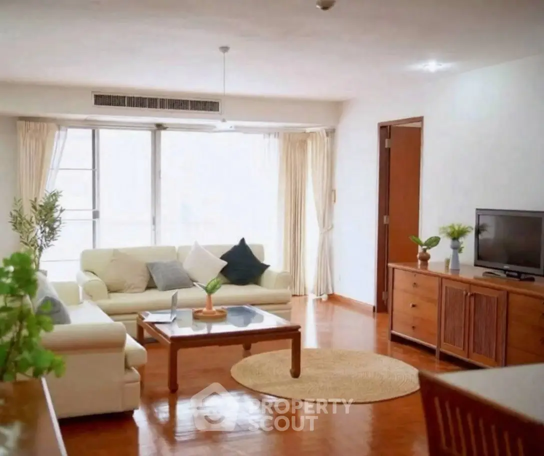 Spacious living room with elegant decor and natural light in modern apartment.