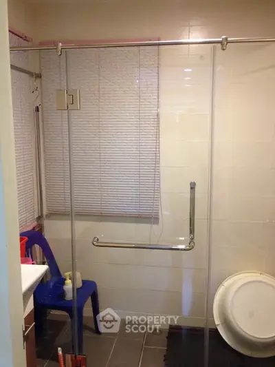 Modern bathroom with glass shower enclosure and sleek fixtures.