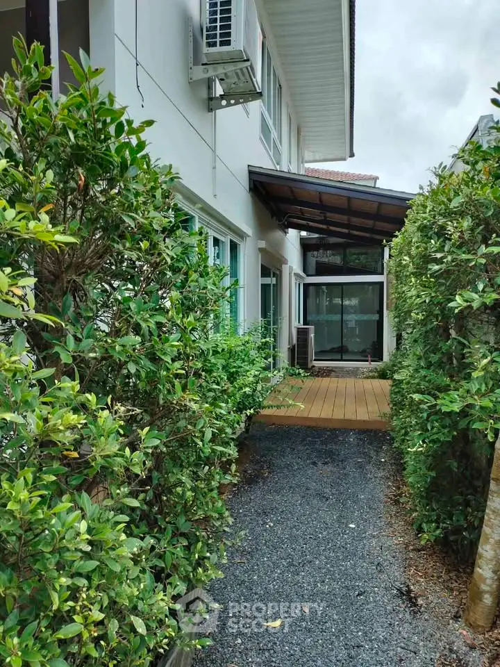 Charming exterior view of modern home with lush greenery and inviting pathway.