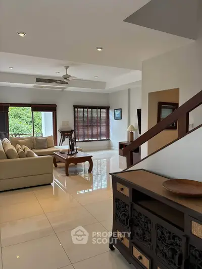 Spacious living room with elegant decor and large windows offering natural light.